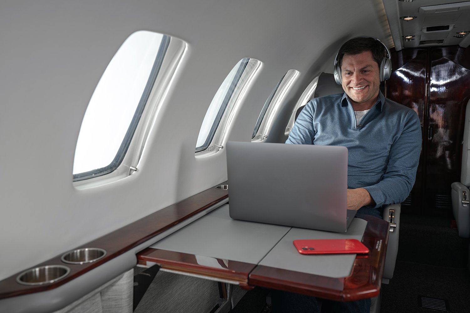 male-business-aviation-passenger-enjoying-inflight-connectivity-on-multiple-devices