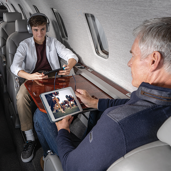 Man and Son watching football on plane